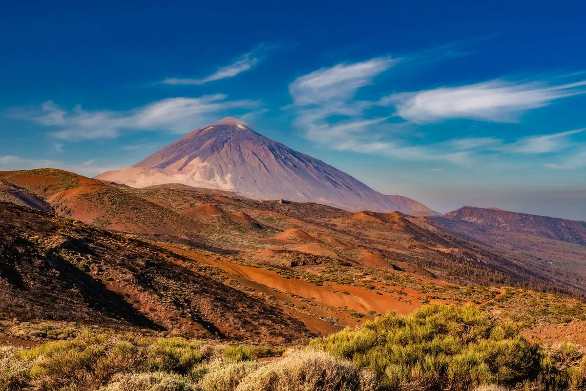 Mount Teide rising above the red volcanic plain of Teide National Park